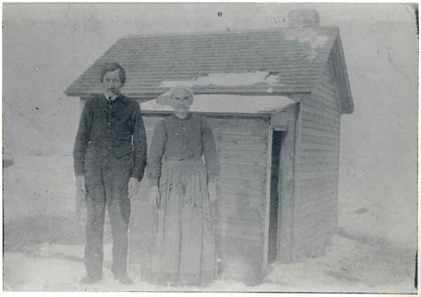 Martin Schlachter and Justina Tschosick standing in front of their homestead home