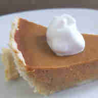 Slice of pumpkin pie with dollop of whipped cream